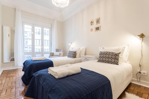 里斯本克鲁兹公寓的一间卧室配有两张带蓝白色床单的床