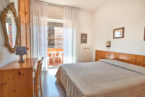 菲纳莱利古雷Albergo Natalina的一间卧室配有一张床、一张书桌和一个窗户。