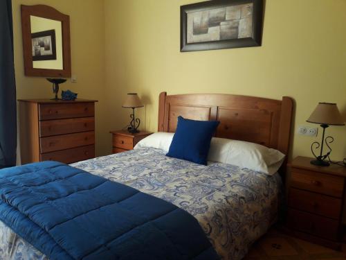 比纽埃拉Apartamentos Vista La Maroma的一间卧室配有一张带蓝色棉被的床