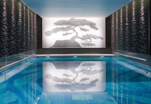 伦敦伦敦朗廷酒店的墙上有盆景艺术的游泳池