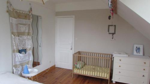 Épagne-ÉpagnetteCôté Prairie的一间卧室配有婴儿床,房间内设有楼梯