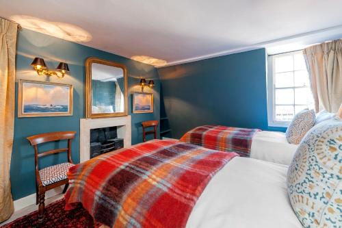 巴斯Luxury Regency Apartment in Bath City Centre的一间卧室设有两张床和一个壁炉