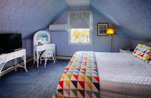 五月岬郡路德奥格登住宿加早餐旅馆的一间卧室配有一张床、一台电视和一个窗口