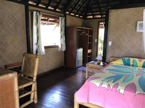 Pihaena莫图伊提公寓的卧室配有床、椅子和窗户。