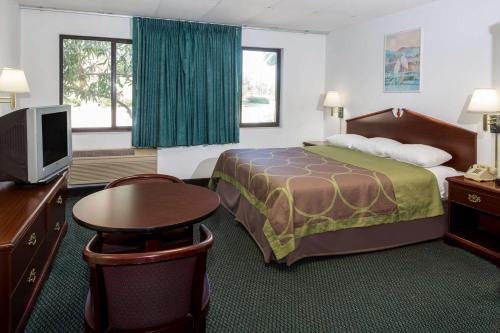 帕诺滩Super 8 by Wyndham Pompano Beach的配有一张床和一台平面电视的酒店客房