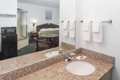 帕诺滩Super 8 by Wyndham Pompano Beach的一间酒店客房内带水槽的浴室