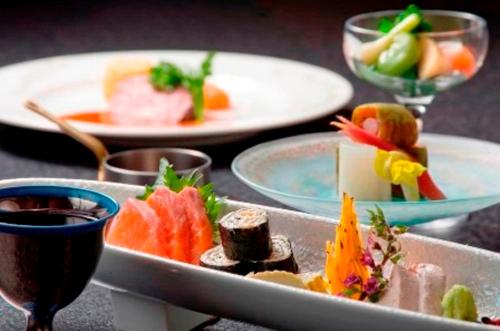 Hayakawa西山温泉日式旅馆的餐桌,带食物盘和酒杯