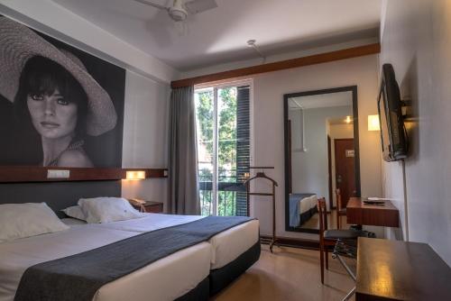 丰沙尔杜卡尔穆酒店的一间酒店客房,配有一张带女性照片的床