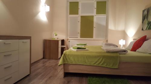 波兹南Apartament w Starej Kamienicy的一间卧室配有一张带绿色床单的床和梳妆台。