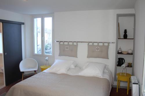 穆斯捷-圣玛丽朱尔旅馆的卧室配有白色的床和椅子