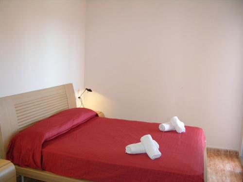 拉曼加戴尔马尔梅纳Penthouse Los Miradores del Puerto的一间卧室配有红色的床和2条毛巾