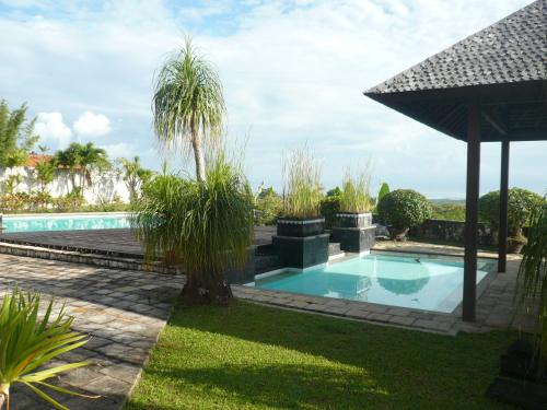 乌鲁瓦图The Rishi Villa Balangan的棕榈树庭院中的游泳池
