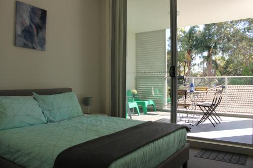 Waitara六人行快乐度假屋的一间卧室设有一张床,阳台设有庭院