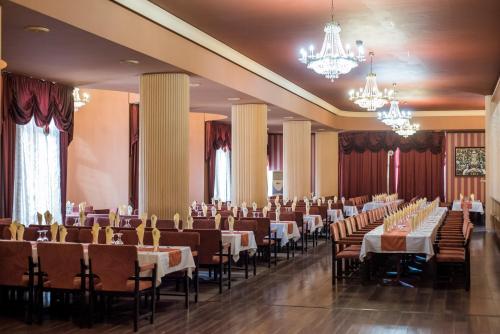 普列文Hotel Balkan的宴会厅配有桌椅和吊灯