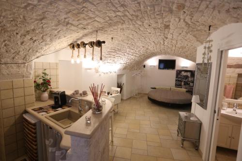 普蒂尼亚诺Casa Vacanze Il Rifugio Del Principe的一个带水槽的厨房和一间客厅