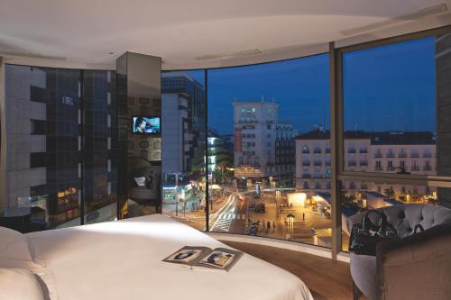 马德里圣多明戈酒店的卧室设有大窗户,享有城市美景