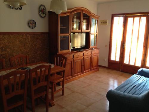 利乌玛Chalet turistico Riumar的客厅配有餐桌和电视