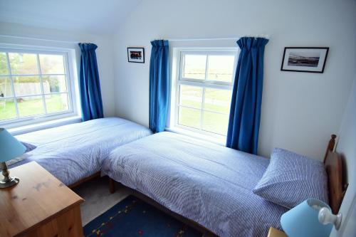 淡水Tollgate Cottages Bed and Breakfast的一间卧室设有两张床和窗户。