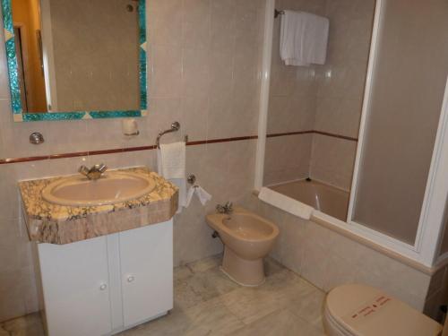 贝纳尔马德纳滨海赌场酒店的浴室配有盥洗盆、卫生间和浴缸。