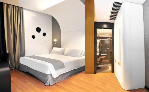 那不勒斯特罗斯托里科文化酒店的一间带白色床的卧室和一间浴室