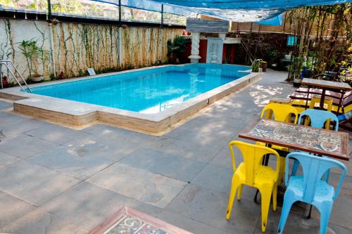 巴姆博利姆Casa Menezes - A Heritage Goan Homestay的旁边设有桌椅的游泳池