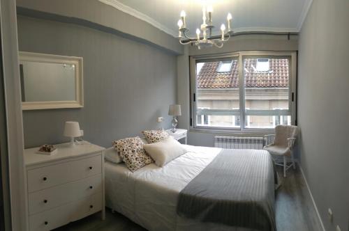 圣地亚哥－德孔波斯特拉Torre Center的一间卧室配有带梳妆台和窗户的床。