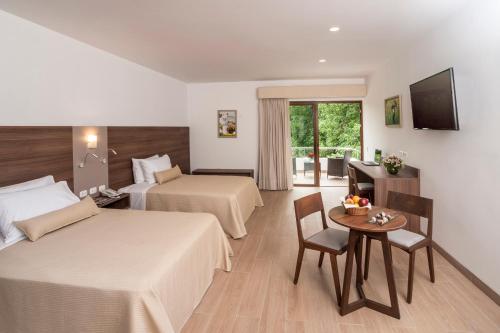 伊察拉斯登纳斯酒店的酒店客房设有两张床和一张桌子。