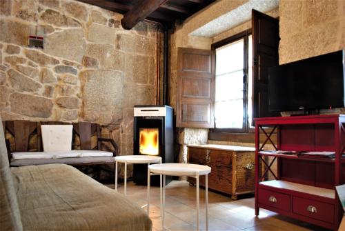 阿拉力兹A Lareira De Allariz的客房设有壁炉、床和椅子。