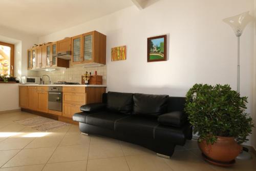 FiavèFerienhaus Irene, Fiave的一间带黑色沙发的客厅和一间厨房