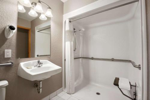 绿湾绿湾I-43商务园速8汽车旅馆的白色的浴室设有水槽和淋浴。