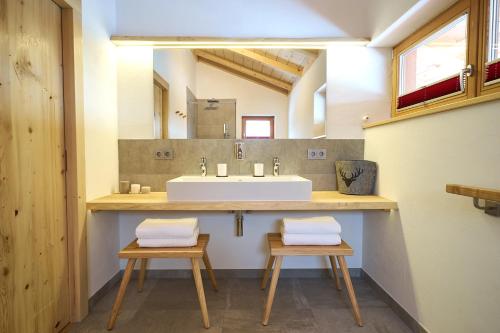 奥巴拉马高Ferienhaus In den Bergen的浴室设有水槽和2把凳子