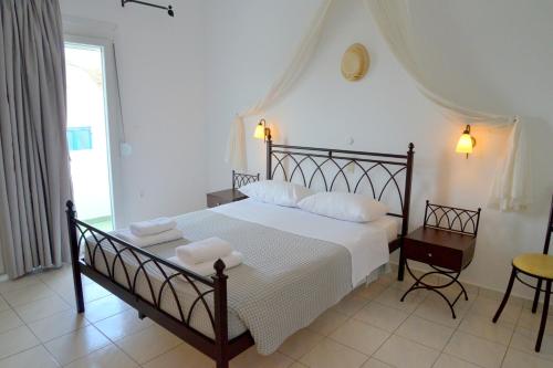 阿波罗尼亚Glaronisia Hotel的一间卧室配有一张床、一张桌子和一个窗户。