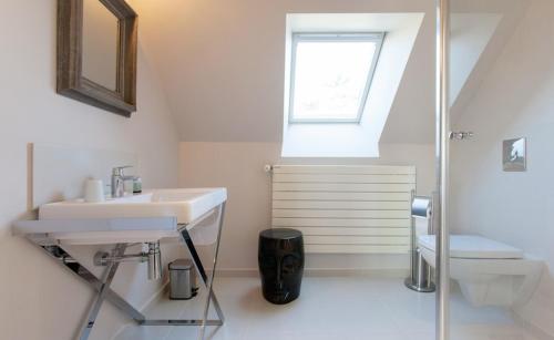Le Minihic-sur-RanceLa Maison Les Mimosas的一间带水槽和卫生间的浴室以及窗户。