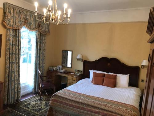 诺里奇Stower Grange Hotel的一间卧室配有一张床、一张书桌和一个窗户。