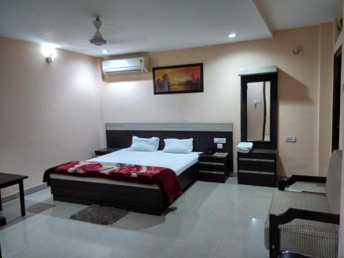 迪布鲁加尔Hotel Raj Palace的一间卧室配有一张床、一张桌子和一面镜子