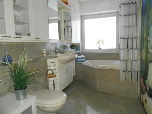 哈夫克鲁格Sunhaus Koch的浴室配有卫生间、浴缸和水槽。