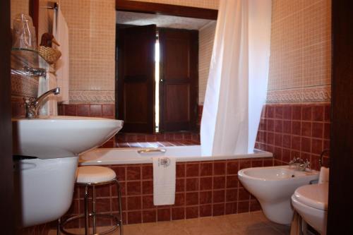 Freixinho卡尔穆夫人修道院酒店的一间带水槽、浴缸和卫生间的浴室