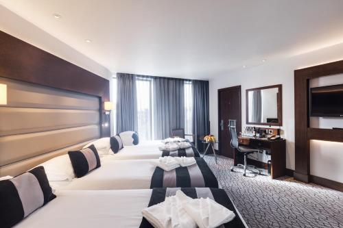 豪士罗Park Grand Heathrow的酒店客房配有两张床和一张书桌