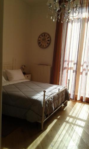 圣塞韦罗Il Nuovo的卧室配有一张床,墙上挂着一个钟