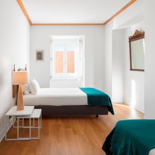 里斯本帕拉西奥贾梅士 - 里斯本服务式公寓的白色的卧室设有床和窗户