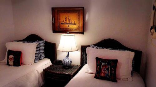 里士满巨石阵住宿加早餐旅馆的一间卧室设有两张床和一张桌子上的台灯。