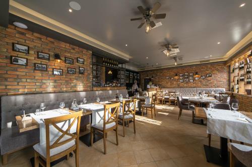 库蒂纳国王酒吧旅馆的一间带桌椅的餐厅以及砖墙
