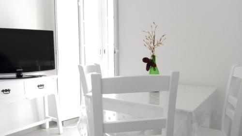 萨尔堡Casa do Rio的一张白色的桌子、一张白色的椅子和一台电视机