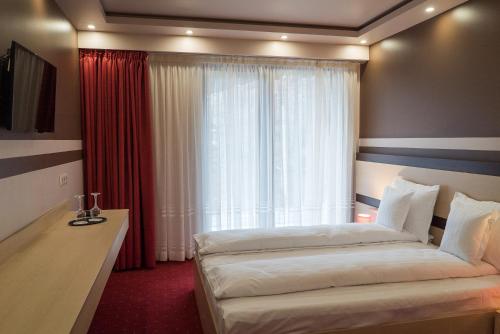 霍莫罗德浴场Homorod Hotel的酒店客房设有两张床和窗户。