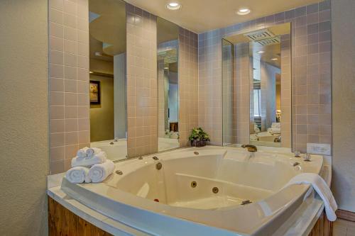 伊格尔里弗飞鹰河旅馆及度假酒店的浴室设有大型白色浴缸,配有镜子