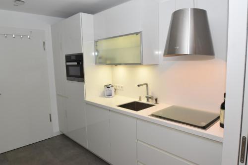 弗伦斯堡Loft 5 - Urlaub direkt an der Förde的厨房配有白色橱柜和水槽