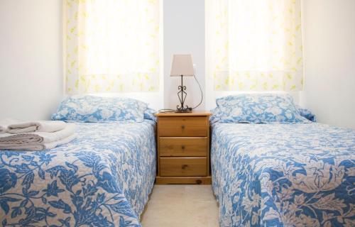 内尔哈菲尔柯马旅游公寓的一间卧室设有两张床、一个梳妆台和窗户。