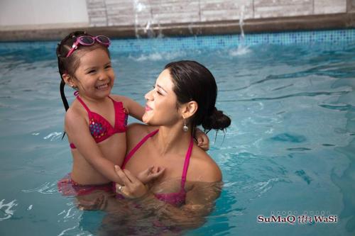 塔克纳Sumaq Wasi Apart Hotel的游泳池里的女人和小女孩