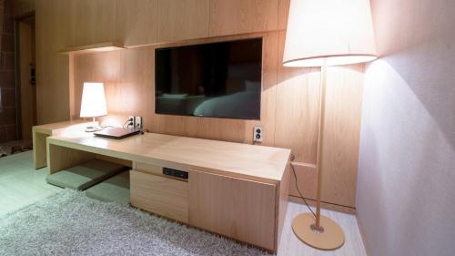 首尔日安酒店的客房设有一张带电视和台灯的书桌。
