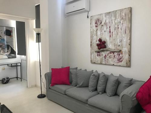 雅典Cosy apartment in Glyfada center的客厅配有灰色沙发和绘画